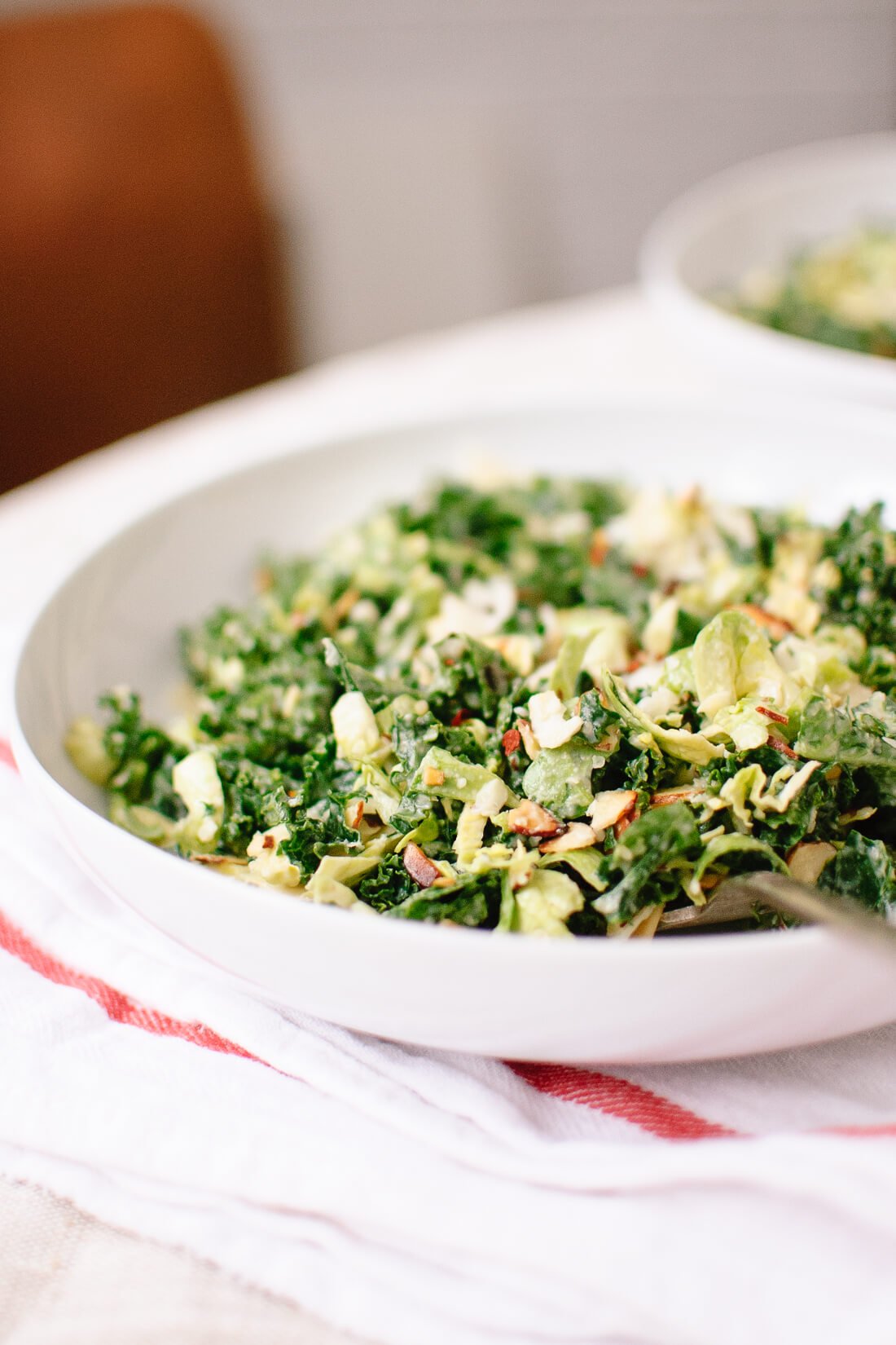 Raw kale and brussels sprouts salad with tahini-maple dressing and toasted almonds
