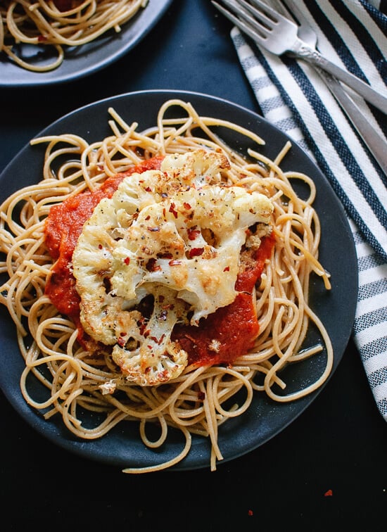 Parmesan crusted, roasted cauliflower "steak" on spaghetti with marinara. This is a super simple, healthy weeknight dinner! cookieandkate.com