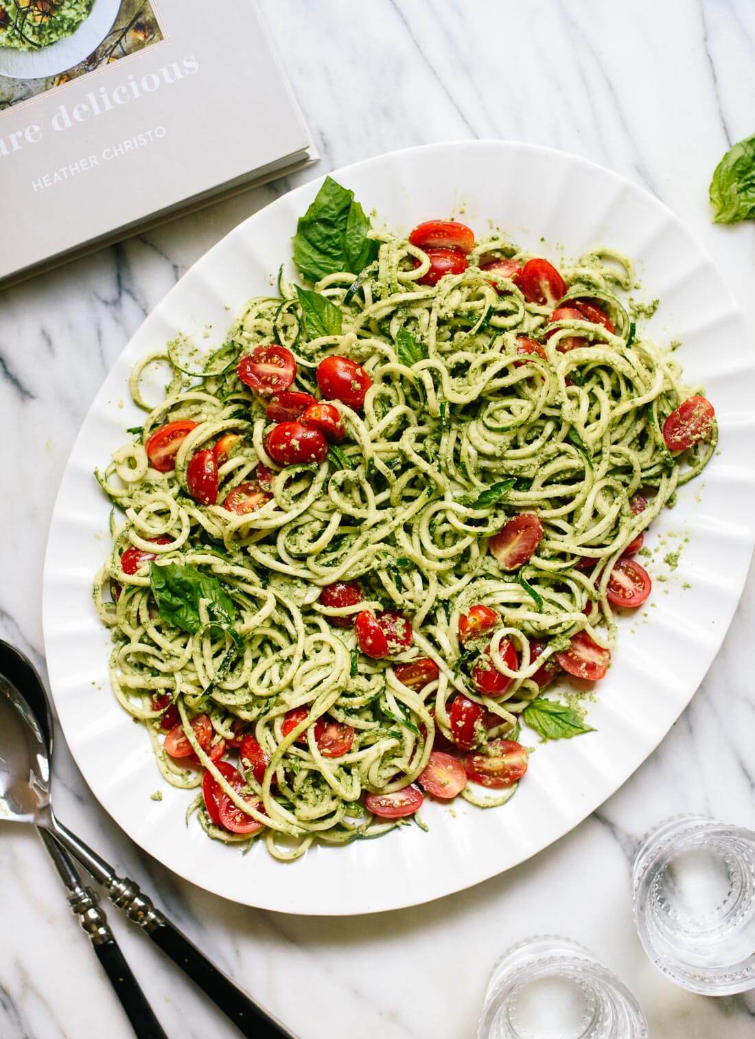 Fresh zucchini noodles with basil pesto and cherry tomatoes makes a light and healthy summer meal! cookieandkate.com
