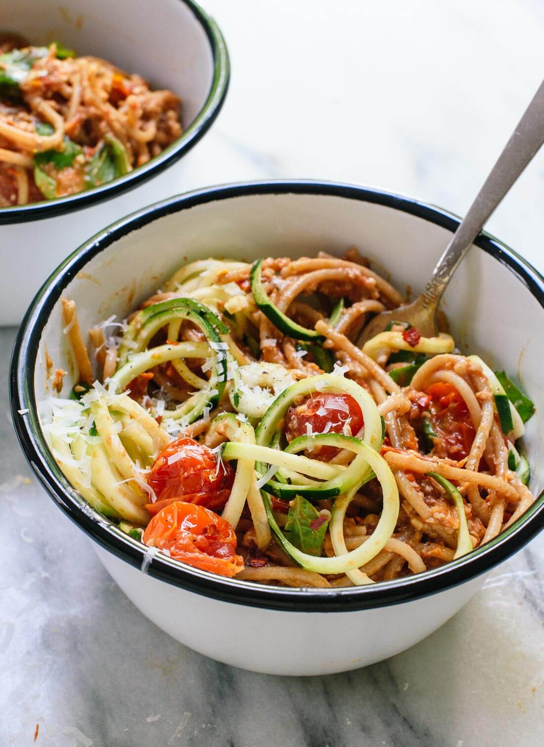 This fresh summer recipe features cherry tomato and sun-dried tomato pesto, zucchini noodles, and spaghetti! It's light and delicious. cookieandkate.com