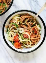 This fresh summer recipe features burst cherry tomatoes, cherry tomato and sun-dried tomato pesto, zucchini noodles, and spaghetti! It's light and delicious. cookieandkate.com