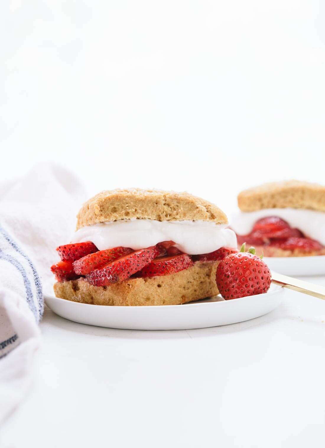 This healthier strawberry shortcake recipe is naturally sweetened, 100% whole grain and made with coconut milk instead of heavy cream! It's delicious and easy to make, too. cookieandkate.com