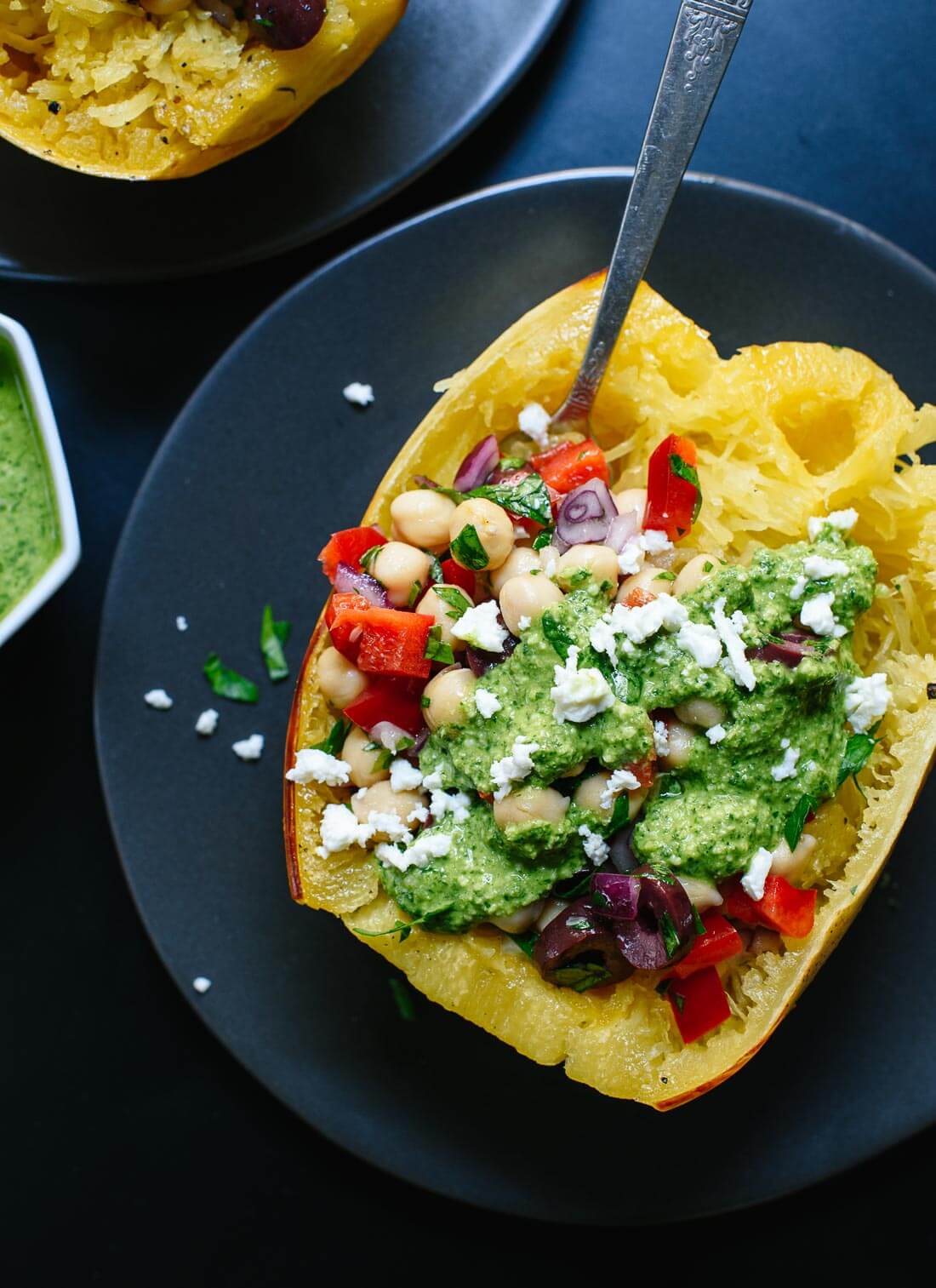 This healthy spaghetti squash recipe features your favorite Mediterranean ingredients, including pesto! It's a great fall dinner. cookieandkate.com