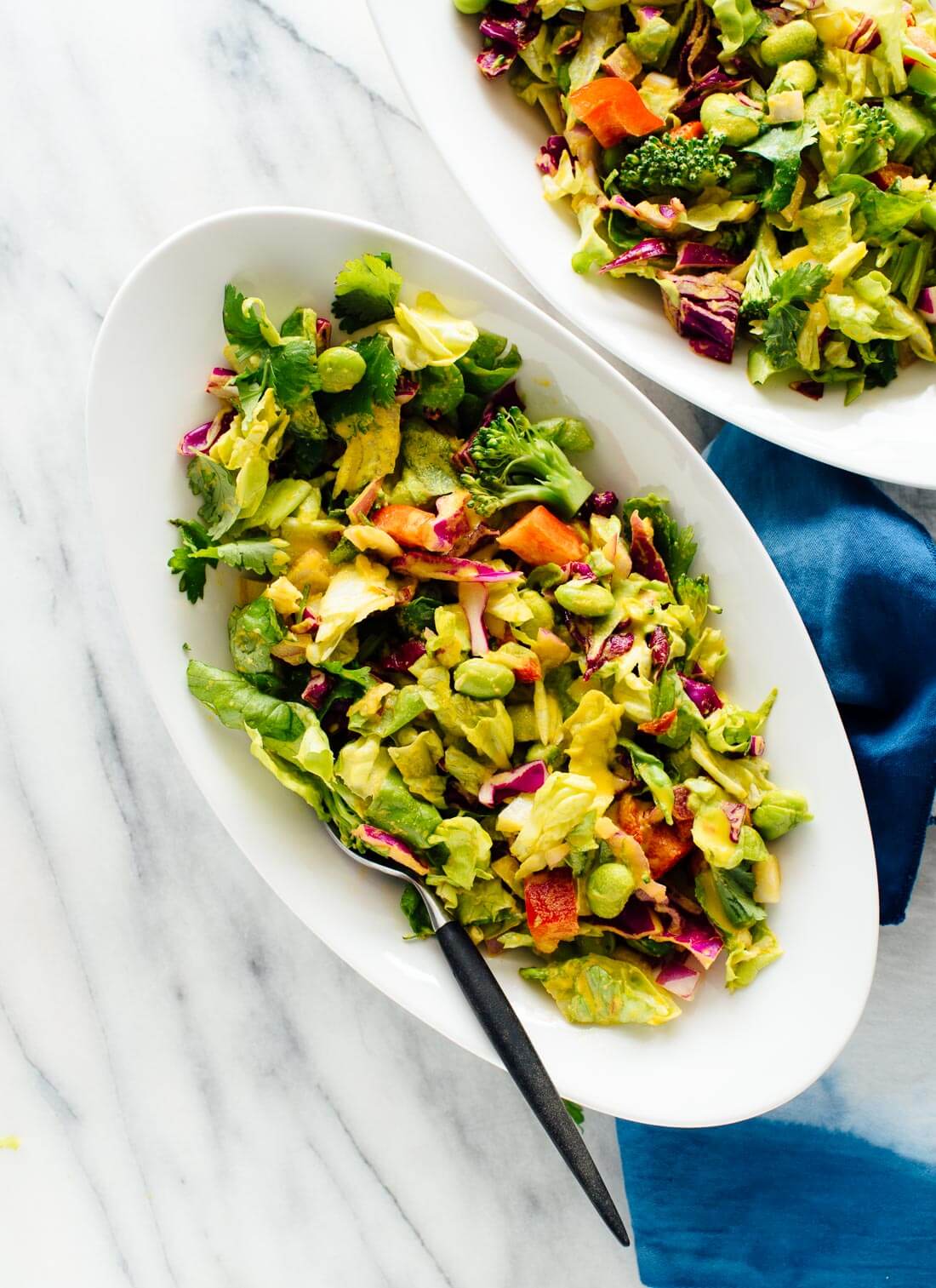 This healthy green salad tastes amazing! Featuring crisp romaine, edamame, chopped cabbage, bell pepper and broccoli in homemade carrot-ginger salad dressing.