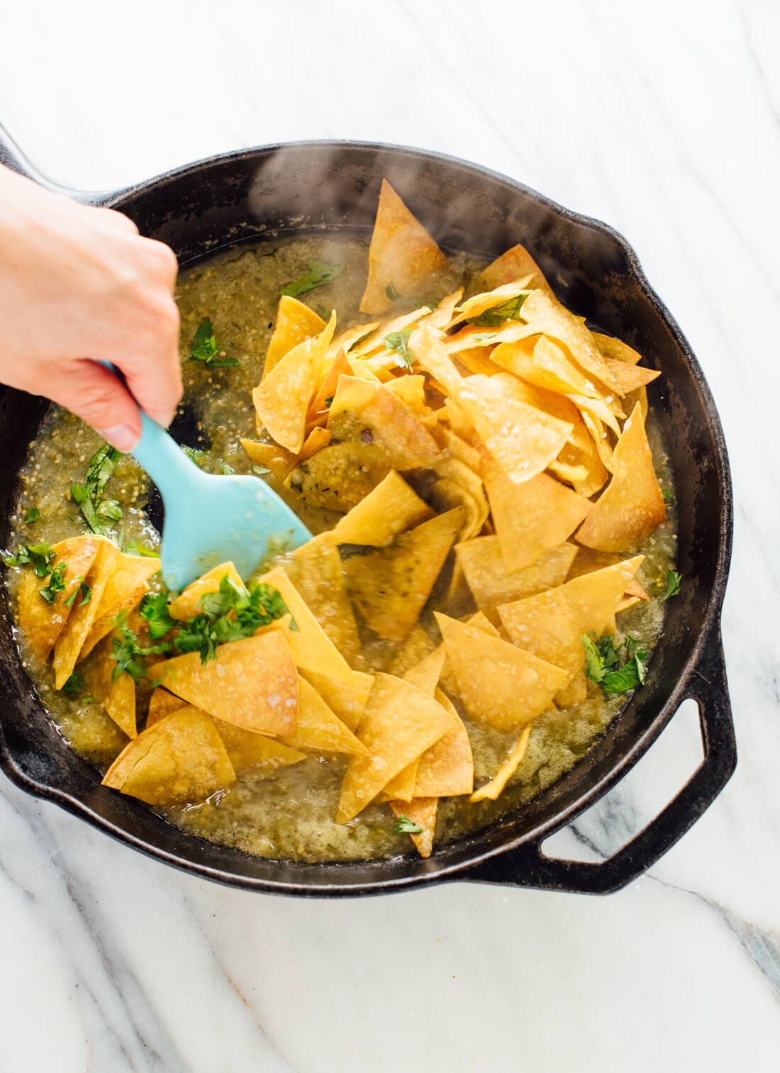 How to make chilaquiles verdes (tortilla chips tossed in warmed salsa verde, often served with fried eggs on top) - cookieandkate.com