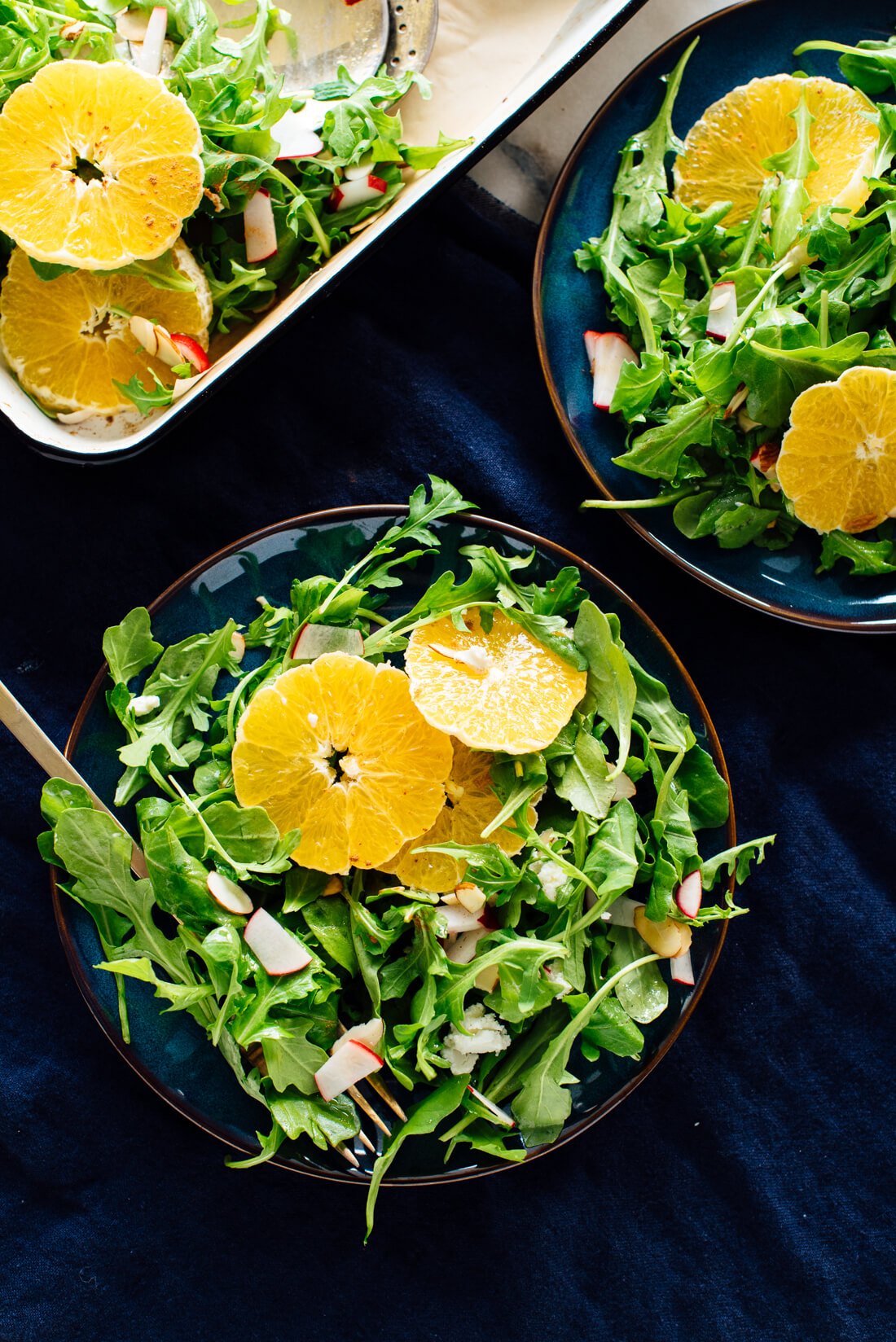 orange arugula salad on plates