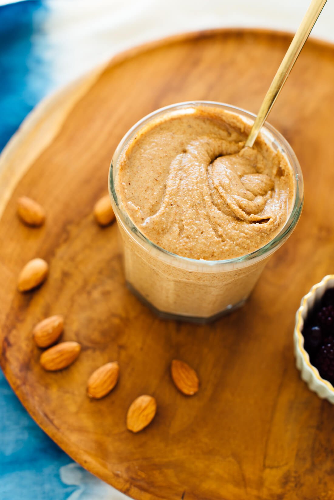 a jar of creamy almond butter surrounded by whole almonds